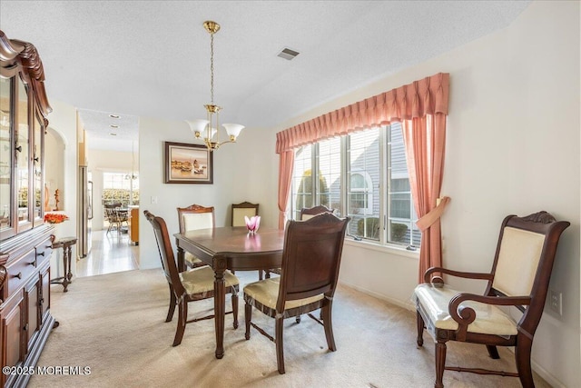 dining room featuring a healthy amount of sunlight, visible vents, light carpet, and an inviting chandelier