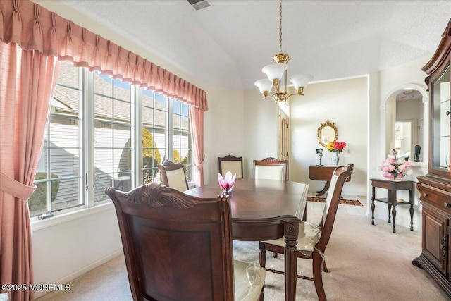 dining area featuring arched walkways, lofted ceiling, light carpet, baseboards, and an inviting chandelier