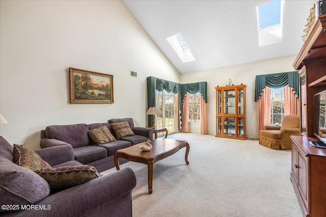 living area with a skylight, visible vents, a wealth of natural light, and light colored carpet