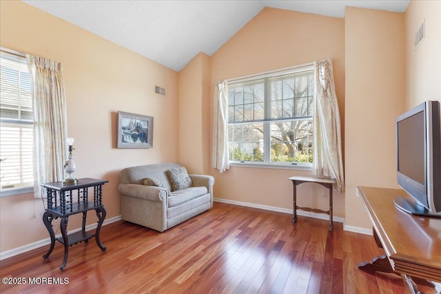 sitting room featuring a wealth of natural light, wood finished floors, and visible vents