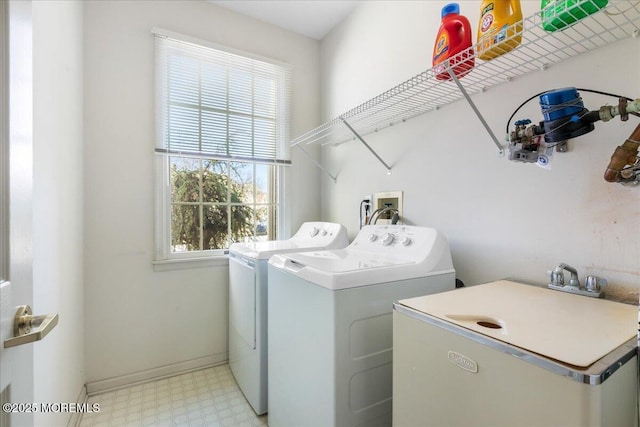 laundry room featuring laundry area, baseboards, washer and dryer, light floors, and a sink