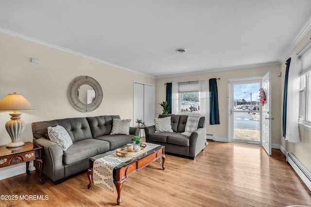 living room featuring ornamental molding, baseboard heating, visible vents, and light wood-style floors