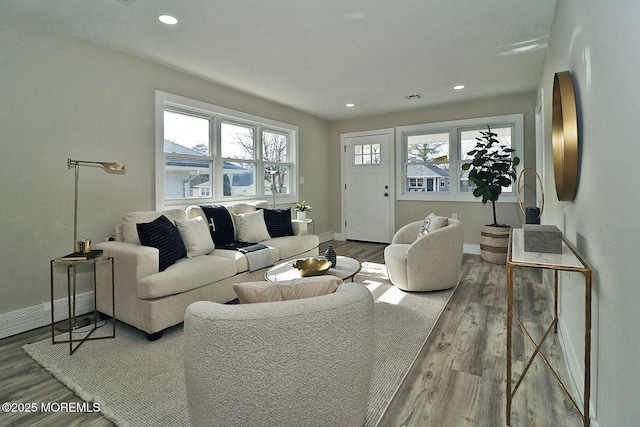 living area with baseboards, baseboard heating, wood finished floors, and recessed lighting