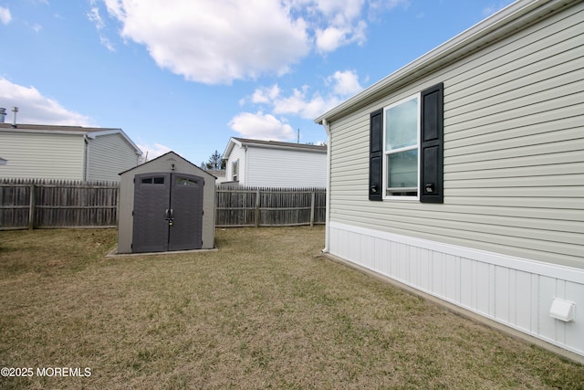 view of yard featuring an outbuilding, a fenced backyard, and a shed