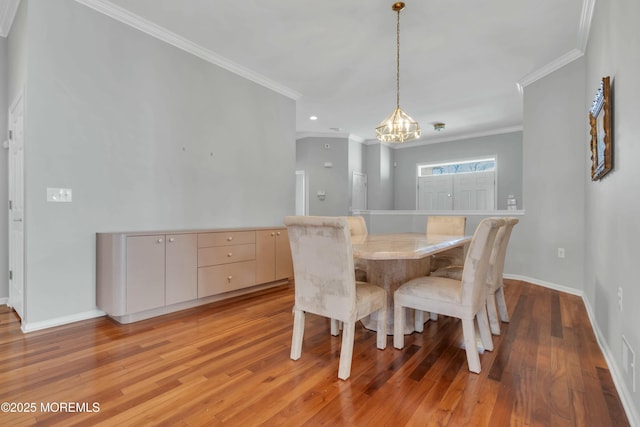 dining room featuring baseboards, an inviting chandelier, light wood-style flooring, and ornamental molding