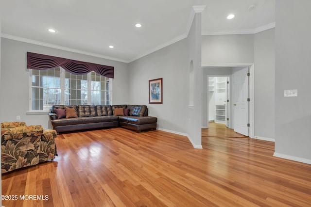 living room featuring crown molding, light wood-style flooring, and baseboards