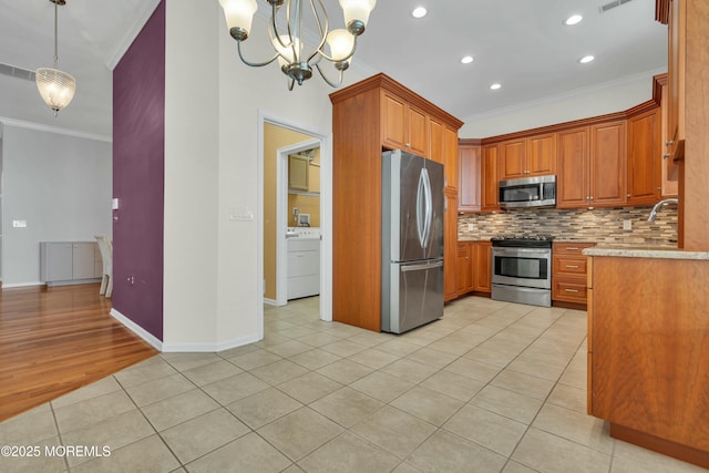 kitchen featuring appliances with stainless steel finishes, crown molding, light countertops, light tile patterned floors, and decorative backsplash