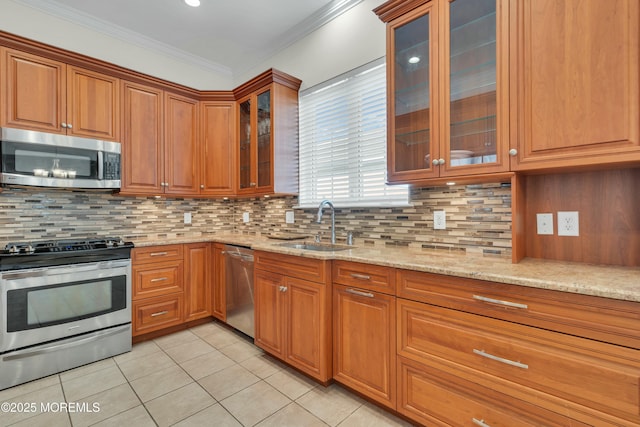 kitchen featuring light stone countertops, brown cabinetry, a sink, appliances with stainless steel finishes, and crown molding