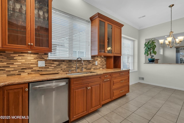 kitchen with tasteful backsplash, visible vents, dishwasher, brown cabinets, and a sink