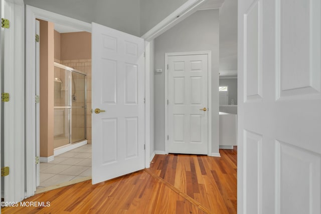 hall with light wood-style floors and baseboards