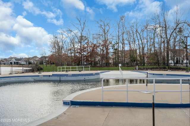 community pool with a patio and fence