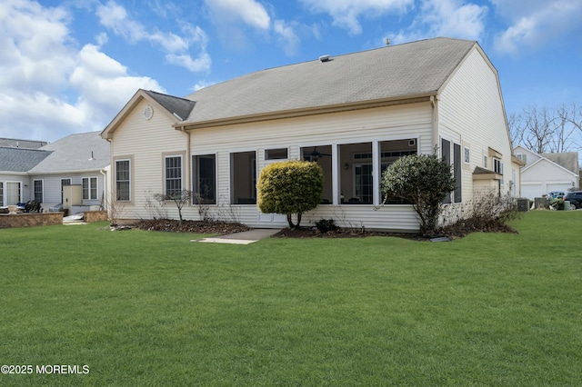 rear view of house with a lawn and a sunroom