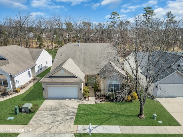 view of front of house with concrete driveway, a front yard, a garage, brick siding, and central AC unit