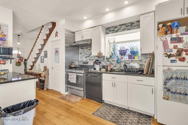 kitchen with under cabinet range hood, black dishwasher, light wood-type flooring, freestanding refrigerator, and gas range