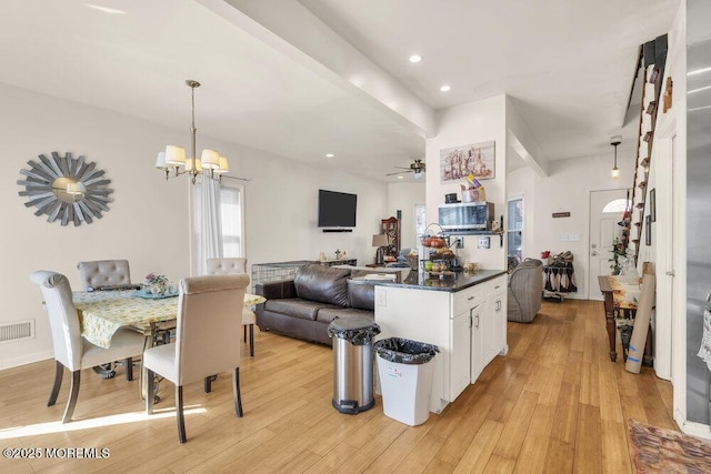 kitchen with white cabinets, light wood-style floors, visible vents, and open floor plan