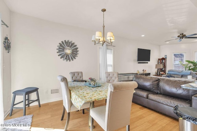 dining space with light wood finished floors, baseboards, visible vents, and a wealth of natural light