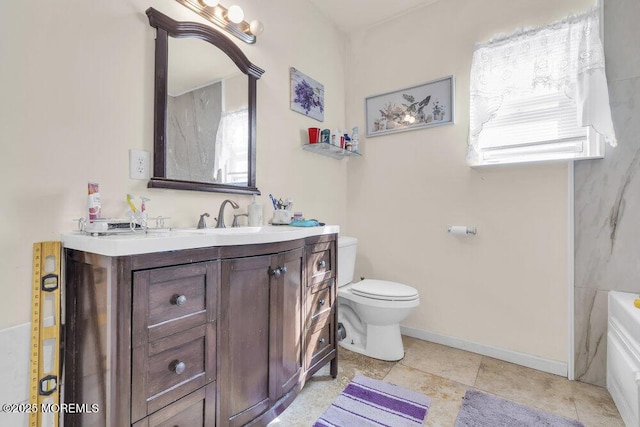 bathroom with a tub, baseboards, vanity, and toilet