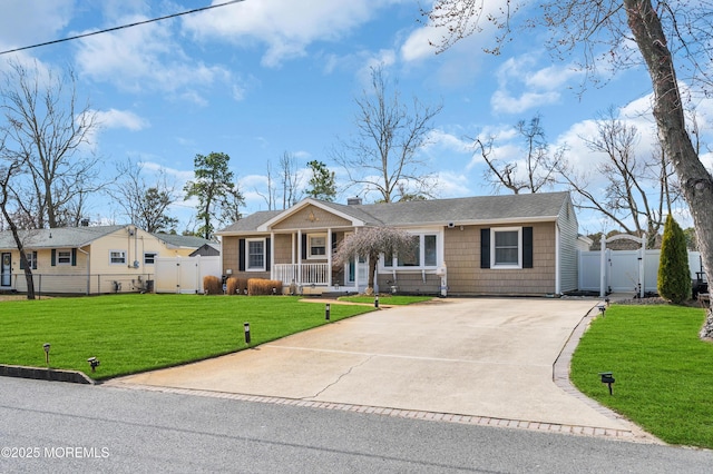 view of front of property featuring driveway, fence, a front yard, and a gate