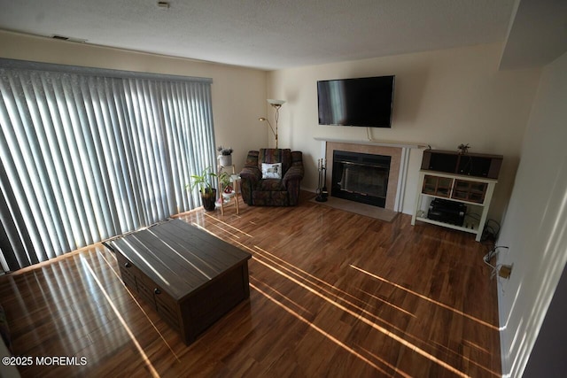 living area featuring a fireplace, wood finished floors, and visible vents