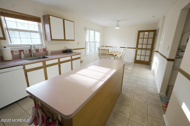 kitchen featuring a sink, a wealth of natural light, white cabinetry, and dishwasher