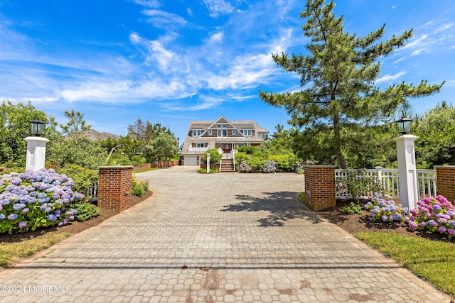 view of front of house featuring decorative driveway and fence