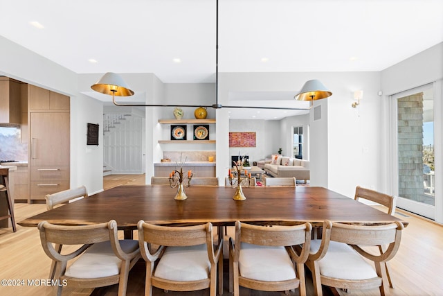 dining room featuring light wood-style floors, recessed lighting, visible vents, and stairs