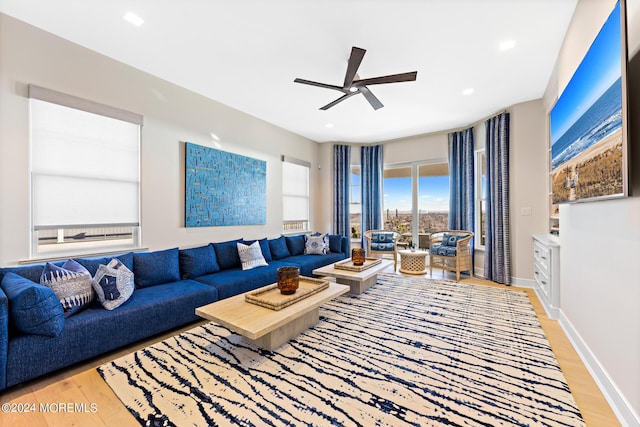 living area with a ceiling fan, recessed lighting, light wood-style flooring, and baseboards