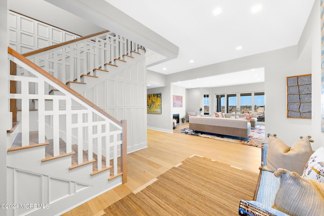 staircase with recessed lighting, baseboards, and wood finished floors