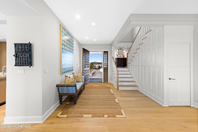 interior space with recessed lighting, a sink, baseboards, stairway, and light wood finished floors