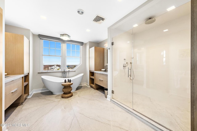 bathroom featuring visible vents, a freestanding bath, vanity, a shower stall, and baseboards