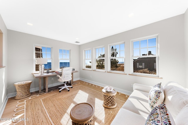 home office featuring visible vents, baseboards, and wood finished floors