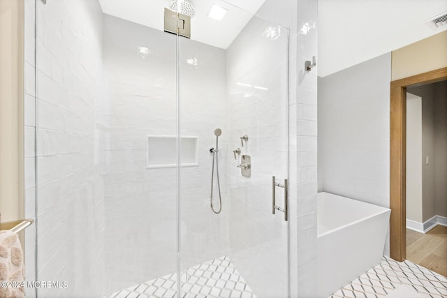 full bathroom featuring a soaking tub, visible vents, a shower stall, and wood finished floors