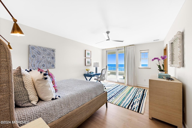 bedroom with access to exterior, ceiling fan, and wood finished floors