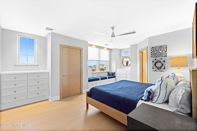 bedroom featuring light wood-style floors, visible vents, baseboards, and a ceiling fan