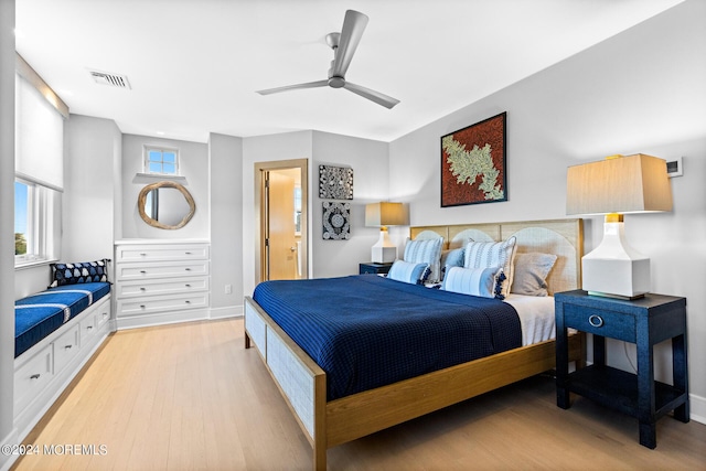 bedroom featuring light wood-type flooring, baseboards, multiple windows, and visible vents