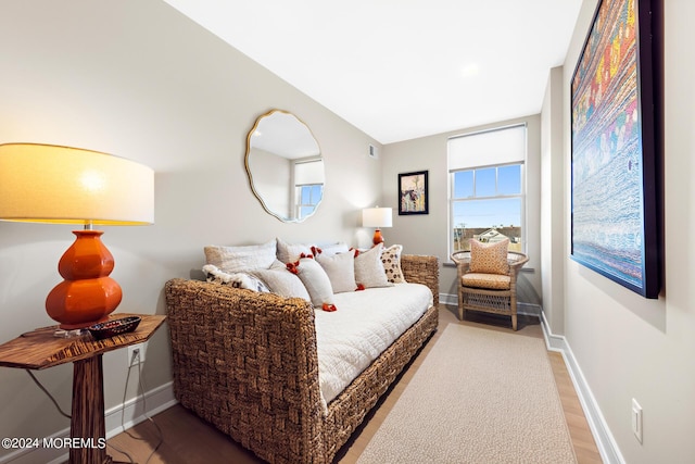 bedroom with wood finished floors, visible vents, and baseboards