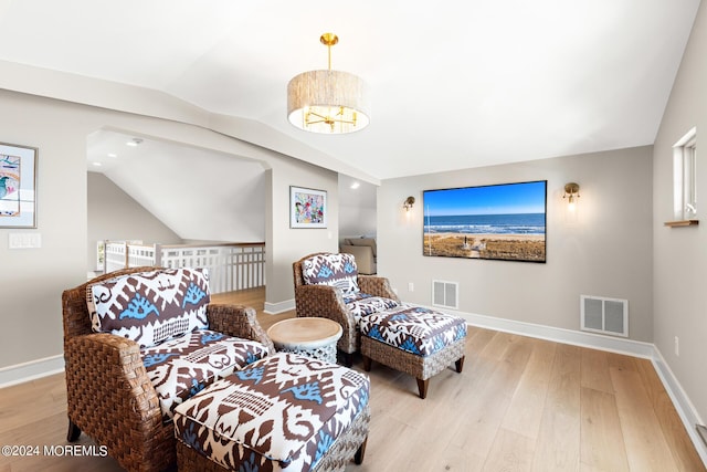 sitting room with lofted ceiling, light wood-style flooring, and visible vents