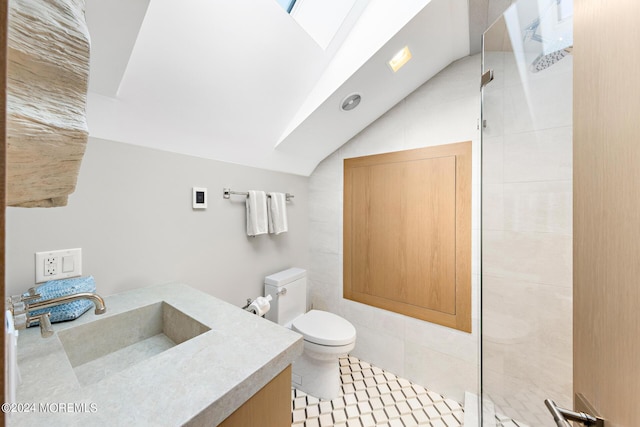 bathroom with toilet, lofted ceiling with skylight, walk in shower, and vanity