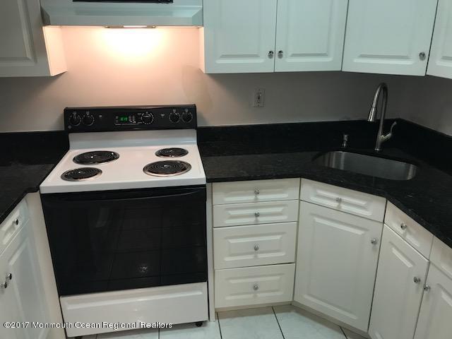 kitchen featuring a sink, white cabinetry, extractor fan, and electric stove