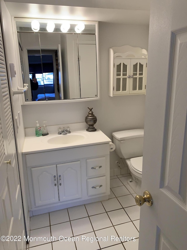 bathroom featuring toilet, tile patterned flooring, and vanity