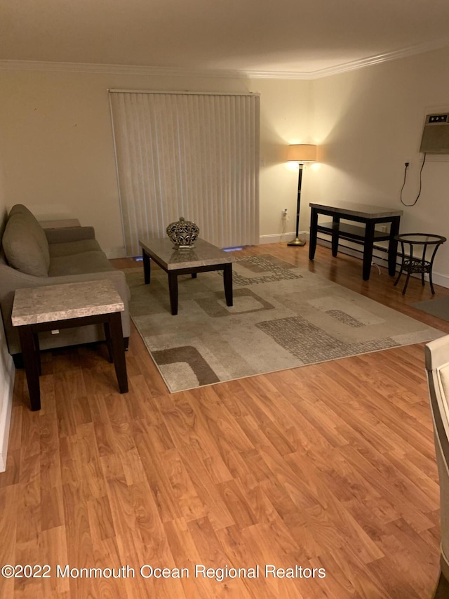 sitting room with crown molding, baseboards, and wood finished floors