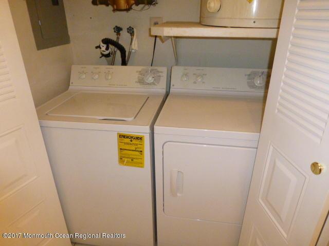 washroom featuring laundry area, electric panel, and washing machine and clothes dryer