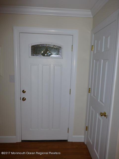 interior space with ornamental molding, baseboards, and wood finished floors