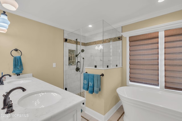 bathroom with a freestanding bath, a stall shower, a sink, and baseboards