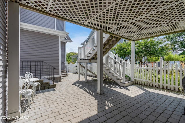 view of patio / terrace featuring stairs and fence