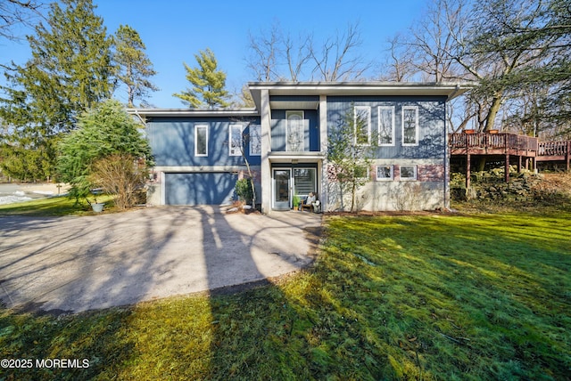 view of front facade featuring aphalt driveway, a garage, and a front lawn