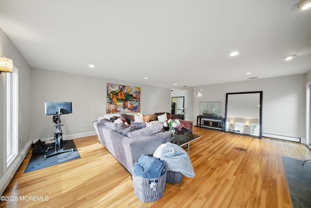 living room with baseboards, baseboard heating, wood finished floors, and recessed lighting