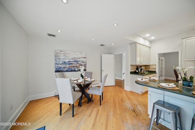 dining room with recessed lighting, a baseboard radiator, visible vents, light wood-style floors, and baseboards