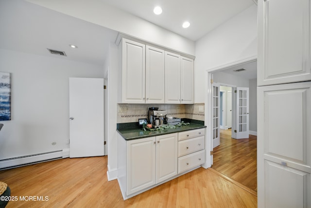 kitchen featuring visible vents, white cabinetry, french doors, backsplash, and dark countertops