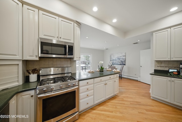 kitchen with stainless steel appliances, light wood-type flooring, dark countertops, and recessed lighting